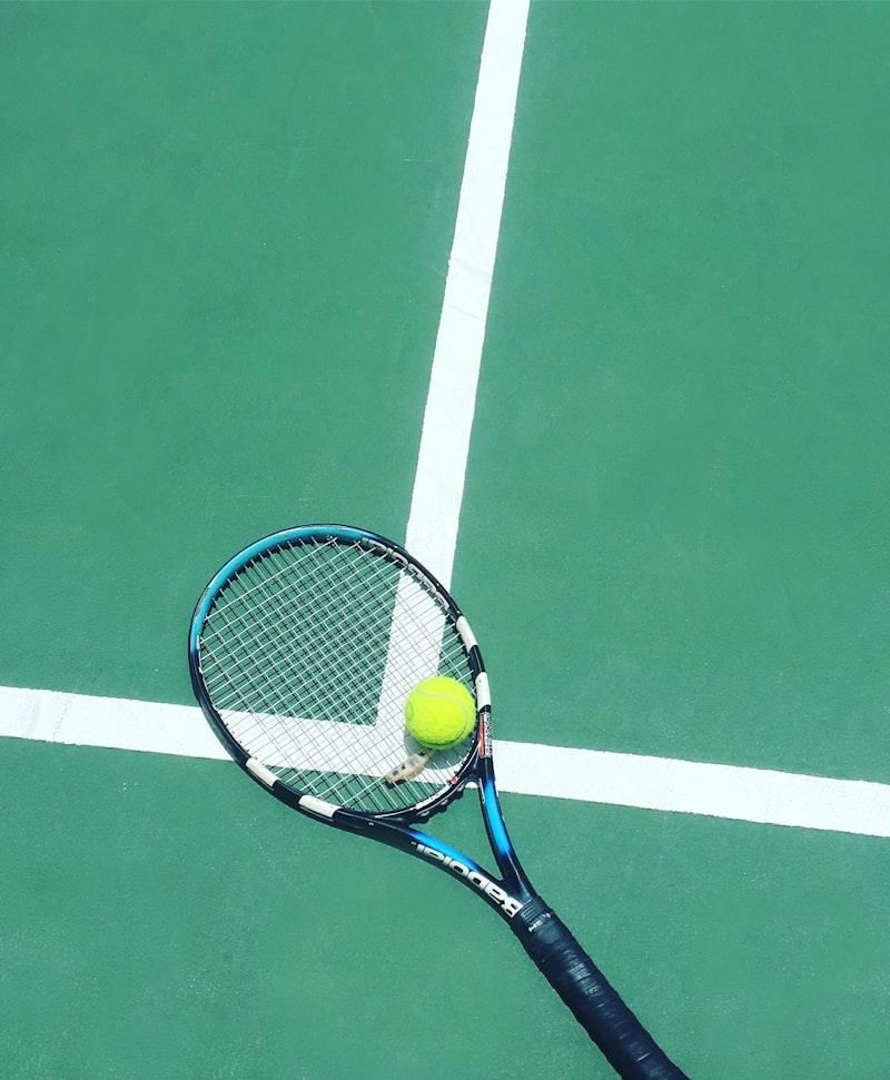 Player on a tennis court mid-rally, racket drawn back for a forehand.